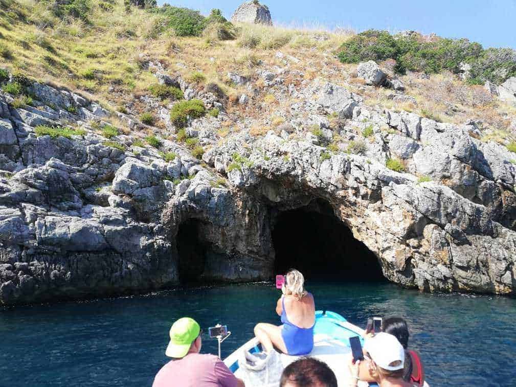 Bucht mit Felsenhöhle, Bootstour, Touristen machen Fotos, Landschaft an der Küste, Meer und Klippen, Natur, Erkundung der Küstenregion, Urlaub am Wasser, Freizeit am Meer, Abenteuer an der Küste.