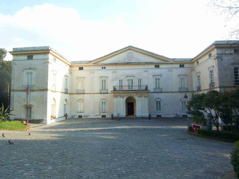9 Palazzi Neoclassici Napoli e Ville Liberty 9 Villa storica in stile neoclassico con facciata bianca e dettagli architettonici eleganti, immersa in un giardino curato, rappresenta un esempio di architettura storica italiana.