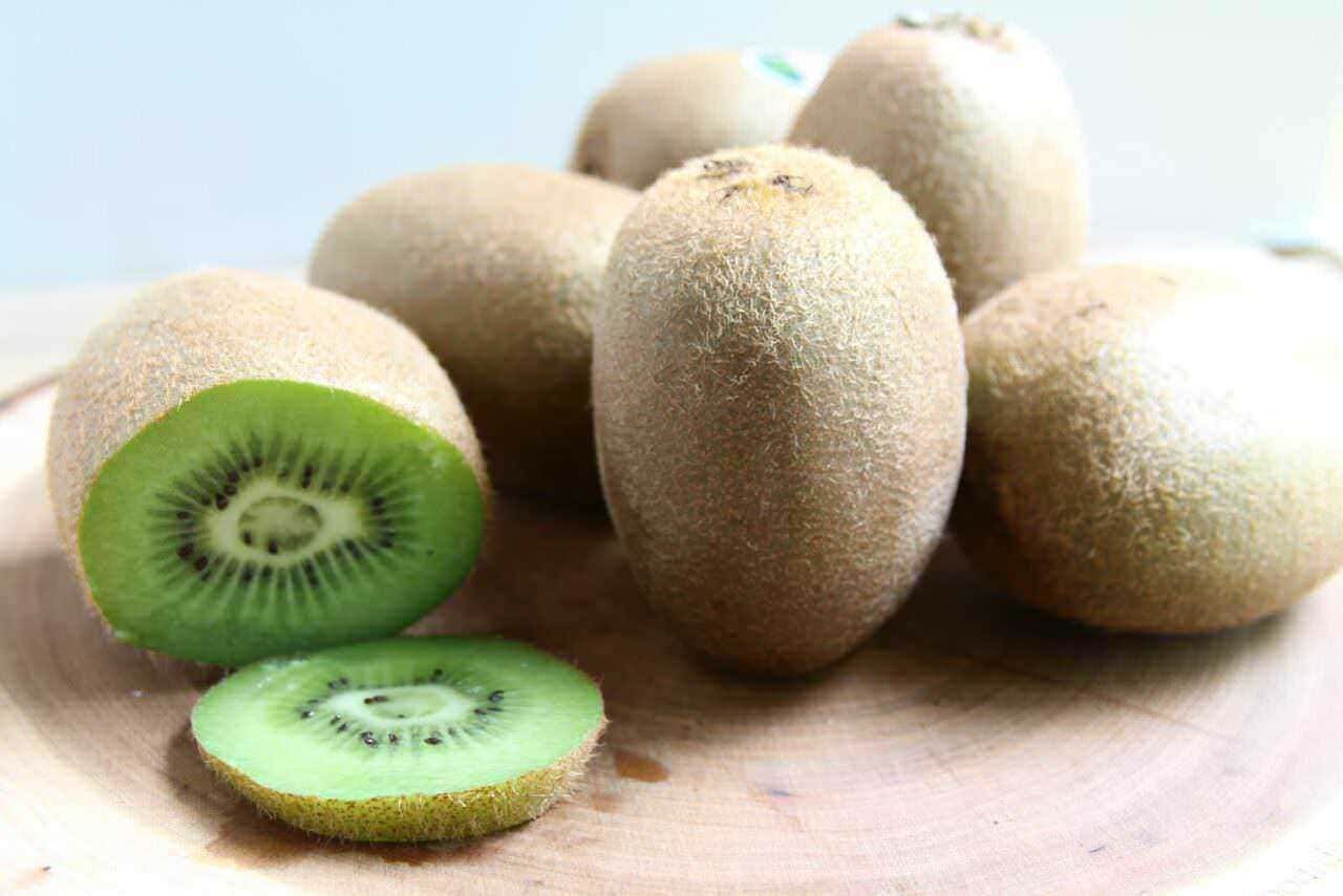 Kiwi e frutti della passione freschi e sbucciati, ideali per uno spuntino salutare e ricco di vitamine. Presentano una polpa verde intensa e semi neri, perfetti per alimenti healthy e ricette di frutta.
