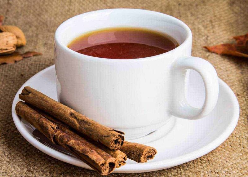 Diabete: alimenti senza zucchero che limitano la glicemia alta 108 Tazza di tè caldo con cannella e spezie, ambiente accogliente, ideale per relaxing invernale, focus su bevande calde, tè aromatico, momenti di comfort e benessere, decorazione rustica.