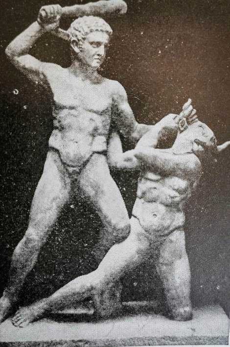 Statuette in marmo che raffigura due guerrieri antichi in combattimento, simbolo di forza e arte classica.