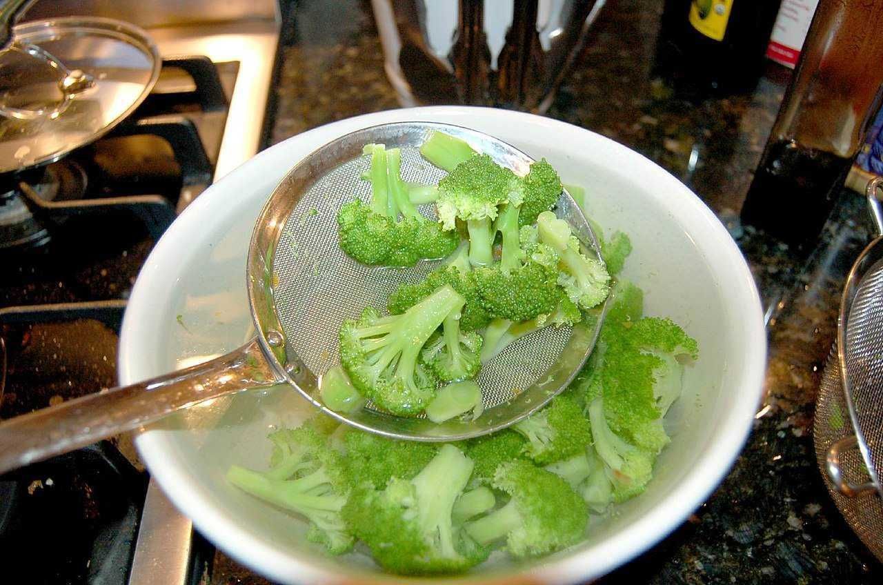 Broccoli freschi a cucinare, cibo salutare e ricco di vitamine, in ciotola bianca.