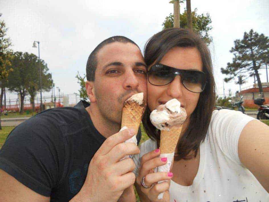 Gelato artigianale in coppetta, coppia felice che gusta gelato all'aperto. Tour estivo, momenti di relax e dolcezza, stile di vita italiano, amici che condividono momenti di piacere.