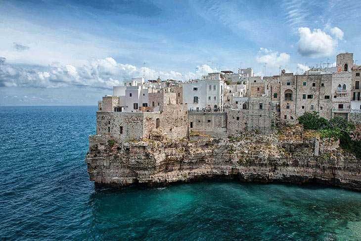 Ville costiere su scogliera, vacanze in Puglia, panorami mozzafiato, case bianche, mare cristallino, turismo in Puglia, destinazioni turistiche italiane, paesaggi marini, vacanze estive, viaggio in Italia.