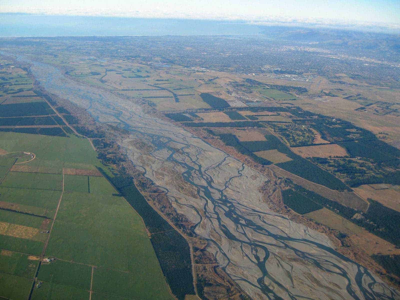 Fiumi e campi agricoli visti dall'alto in un paesaggio rurale con tracce di acqua e terra, perfetto per contenuti di natura, agricoltura e ambienti naturali.
