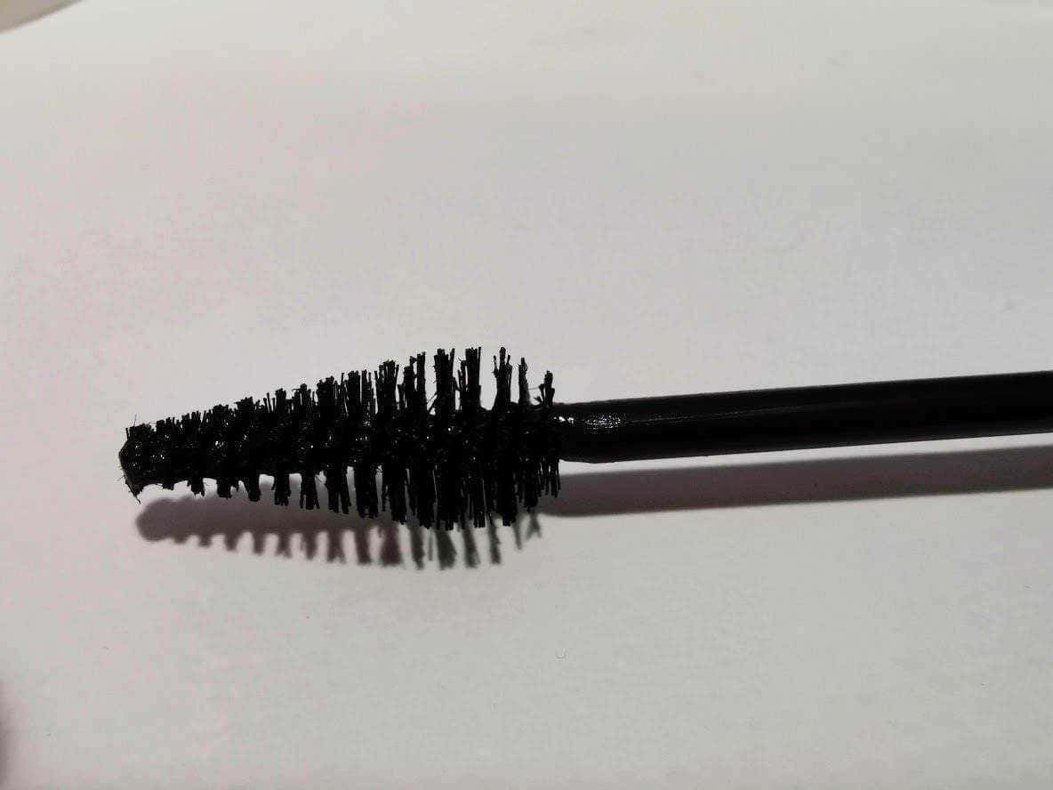 Pennello per trucco con spazzola in nero su sfondo bianco, focus su strumenti di bellezza e make-up, ideale per tutorial di bellezza e recensioni prodotti.