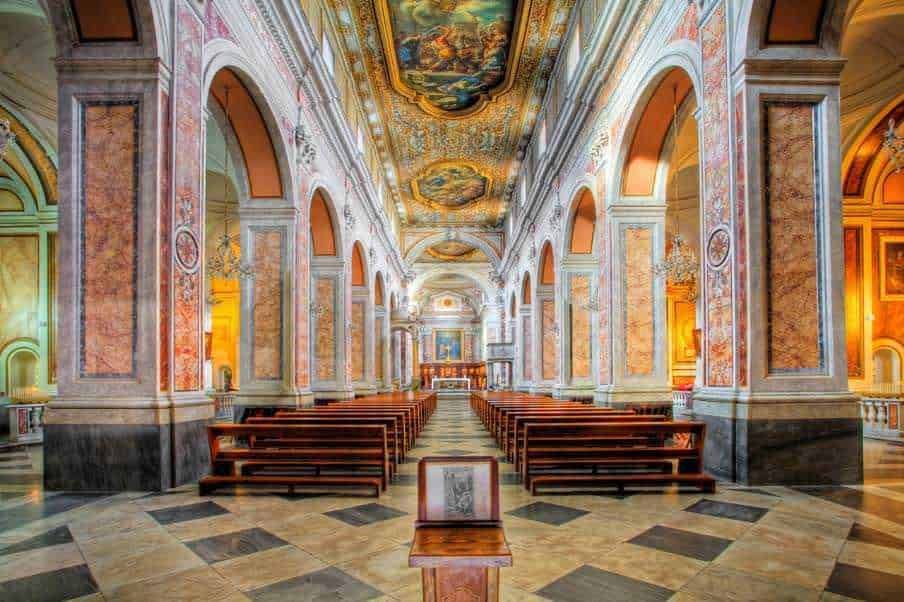 Immagine di una splendida chiesa barocca con affreschi elaborati e arredi in stile dorato, ambientata in un luogo di culto storico e artistico.