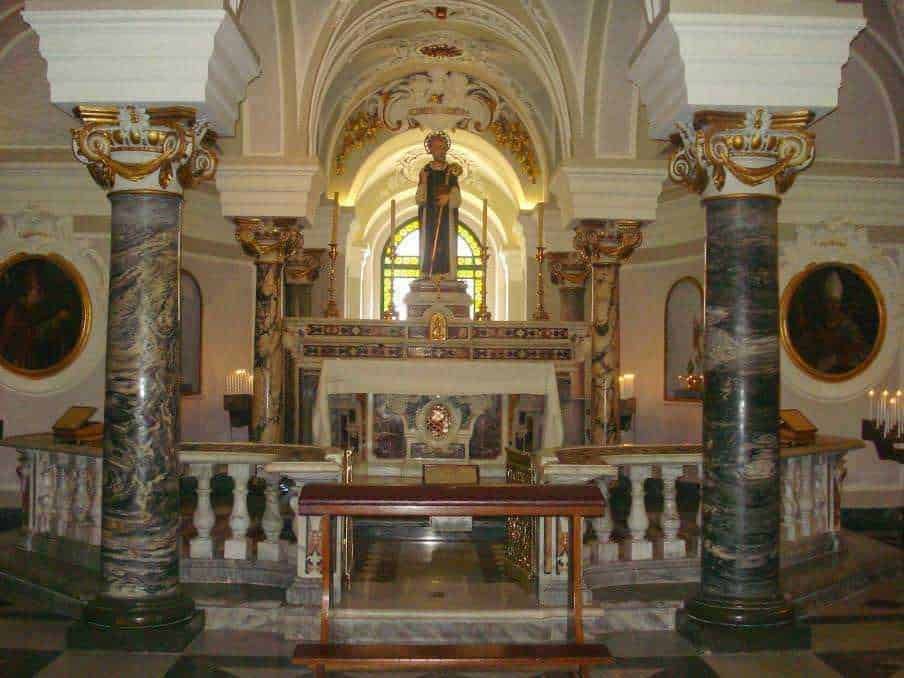 Scultura sacra in chiesa barocca, decorazioni dorate e colonne in marmo, ambiente di culto con atmosfere storiche e spirituali per appassionati di arte religiosa.