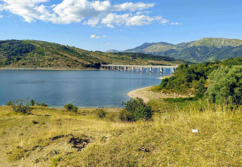 Come si chiama il paesaggio del lago, i principali tipi di laghi 3 Lago tra le montagne con paesaggio naturale, area verde e cielo blu, centrale per l'energia idroelettrica in Italia.