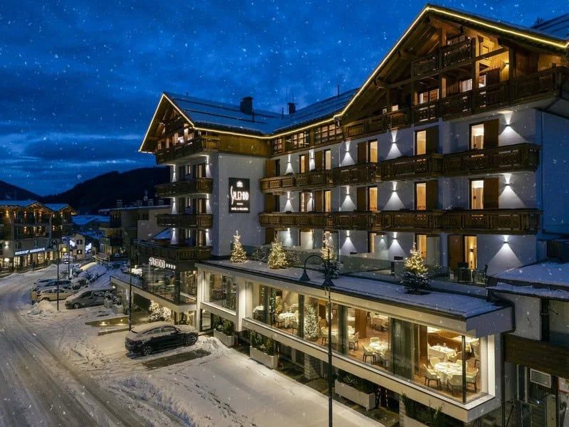 Dormire in un Hotel a Madonna di Campiglio tra neve perenne e laghi azzurri 7 Struttura alberghiera accogliente immersa in un paesaggio invernale con neve perenne, luci calde e balconi in legno, ideale per soggiorni tra natura e relax.