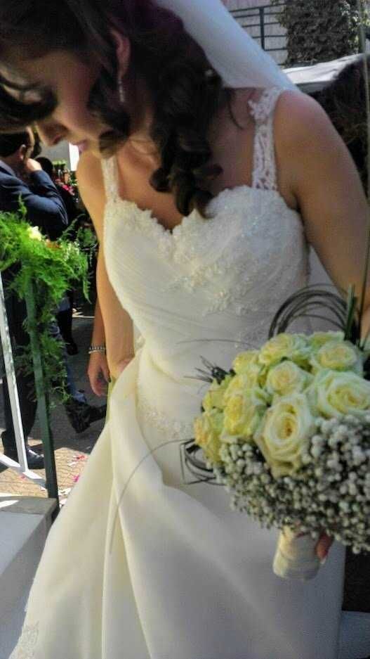 Più bella sposa in abito da matrimonio con bouquet di fiori bianchi, emozionata e sorridente durante il ricevimento nuziale. Ritratto di un momento speciale di un matrimonio elegante e romantico.
