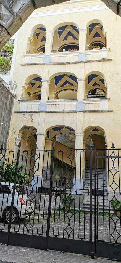 Appunti Sul Blog building con facciata storica e palme, centro città Sicilia, architettura urbana e turismo locale, immagini di carattere storico e culturale, fotografie di luoghi emblematici italiani.