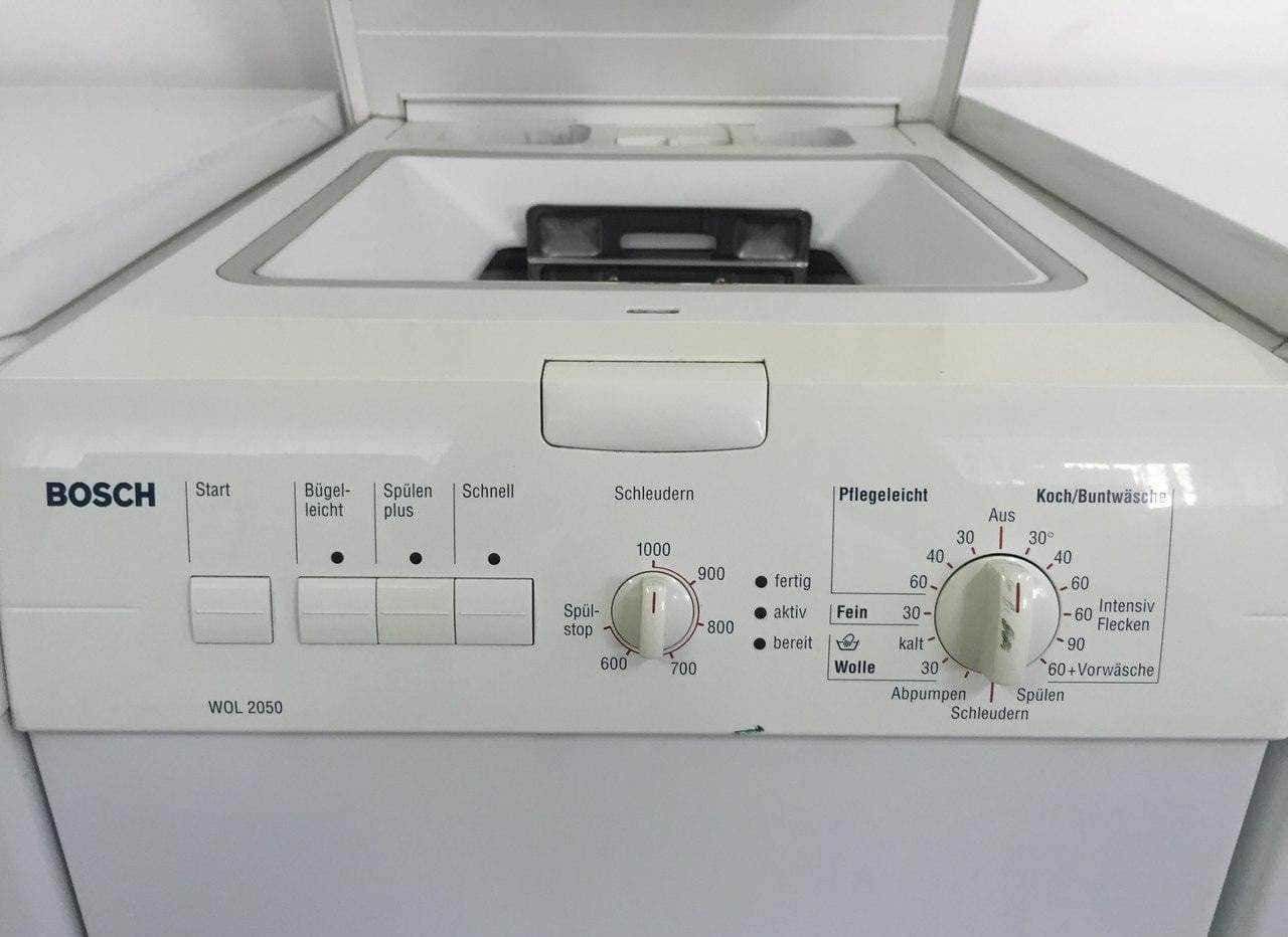 Pulire la lavatrice a carica dall'alto: Lavatrice bianca Bosch con impostazioni di lavaggio e programmi specializzati, vista dall'alto, attrezzature per la cura dei vestiti, tecnologia domestica moderna, guida alle proprietà di lavaggio, efficienza e funzionalità.