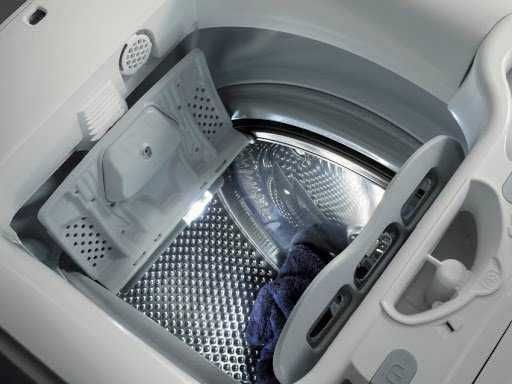 Lavatrice frontale aperta con asciugamano all’interno, dettagli tecnici e contenuto per il lavaggio di vestiti, focus su elettrodomestici e tecnologia.