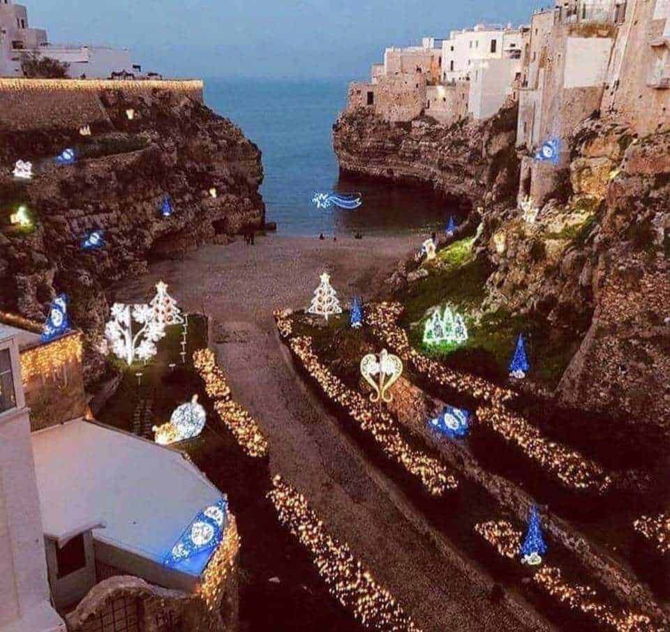 Illuminazioni natalizie sul lungomare di Polignano a Mare, Puglia, in Trentino, decorazioni festive che evidenziano il fascino delle feste lungo la costa adriatica italiana.
