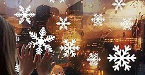 Finestra con decorazioni di fiocchi di neve che osservano un paesaggio urbano al tramonto, creando un'atmosfera natalizia e magica, perfetta per il blog Appunti Sul Blog.