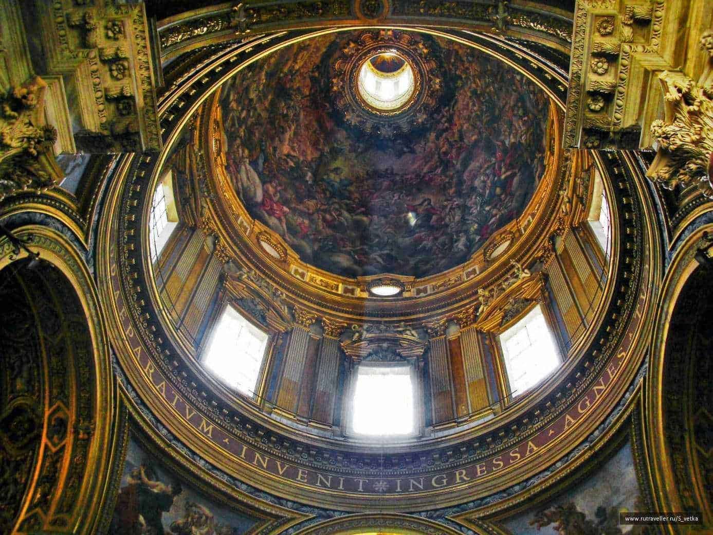 Lusso e arte barocca in una chiesa storica con soffitto affrescato e decorazioni dorate. La cupola mostra dettagli artistici e luminose finestre che illuminano l'interno.