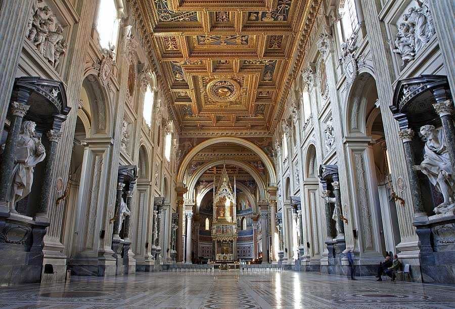 Elegante interiorismo barocco di una chiesa o basilica con statue, archi e affreschi, dettagli artistici e decorativi, luce naturale, ambiente spirituale e storico, ideale per turismo e cultura religiosa.