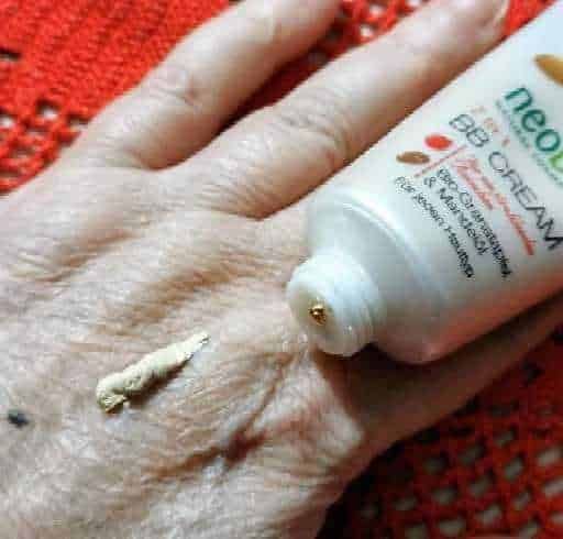Unguento per convinzione e dolori articolari applicato sulla pelle di una mano invecchiata.