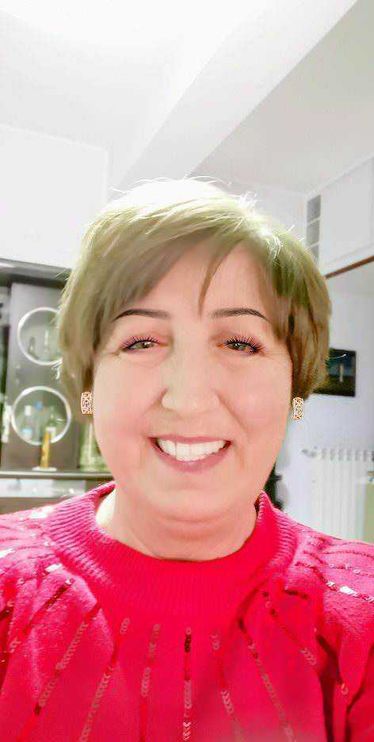 4 regole trucco antietà con BB, ombretto e matita per sopracciglia 3 S mascarada sorridente donna con short hair, indossa un maglione rosso con dettagli glitter, sfondo di ambiente domestico moderno.