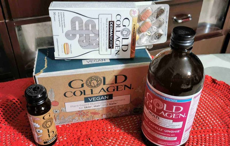 Gold Collagen Vegan, 3 integratori per pelle, capelli e unghie 2 Integratore di collagene vegano Gold Collagen e integratore multivitaminico in bottiglia e scatola, prodotti naturali per pelle, capelli e unghie su tovagliolo rosso, sito Appunti Sul Blog.