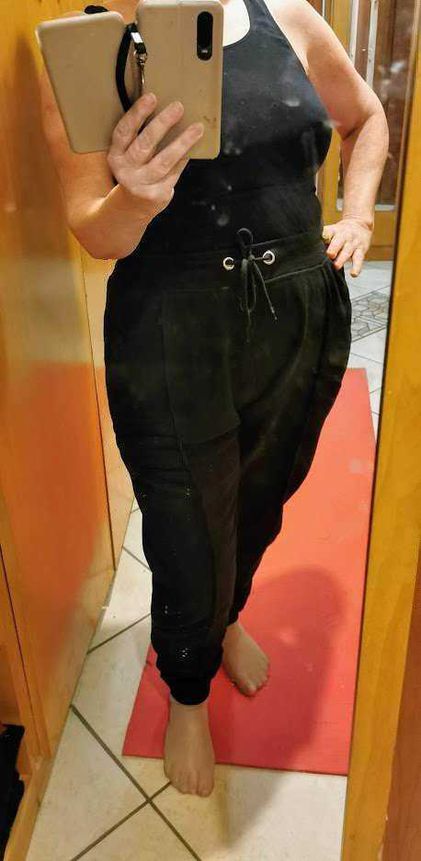 Come vestirsi bene con outfit sportivo ma elegante 7 Completo nero con pantaloni jogger e top senza maniche, specchio per selfie, abbigliamento casual e confortevole.