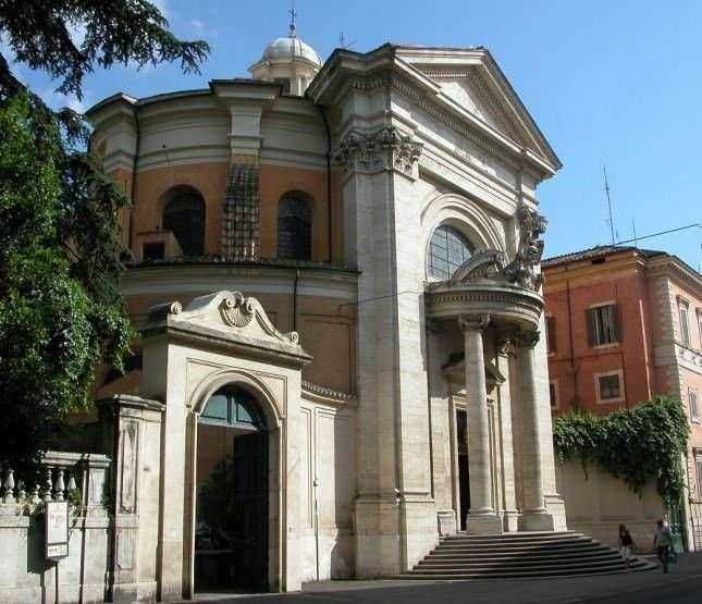 Ingresso barocco di una chiesa storica a Roma, con dettagli architettonici eleganti e colonne monumentali, simbolo di arte e cultura religiosa italiana.