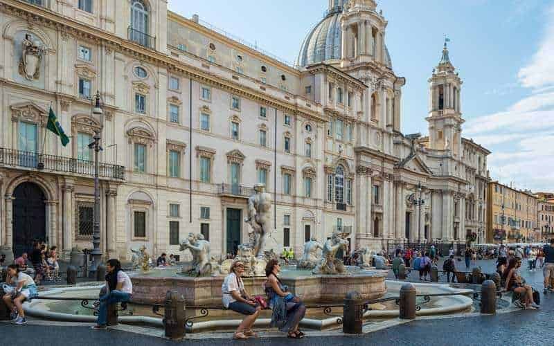 Piazza Navona a Roma in stile barocco 7 Fontana storica con sculture in pietra situata in una piazza di Roma, circondata da edifici storici e architettura classica, ideale per foto turistiche e passeggiate urbane.