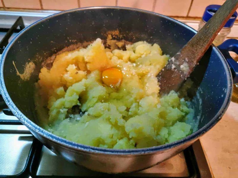 Purè di patate senza latte per vegetariani 4 Uova sbattute con patate crude in padella, preparazione di colazione o ricetta fatta in casa.