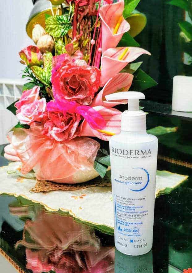 Idratante viso Bioderma Atoderm gel crema con fiori colorati sul tavolo, prodotto skincare dermatologico, idratante e lenitivo per la pelle sensibile, ideale per una routine di cura della pelle.
