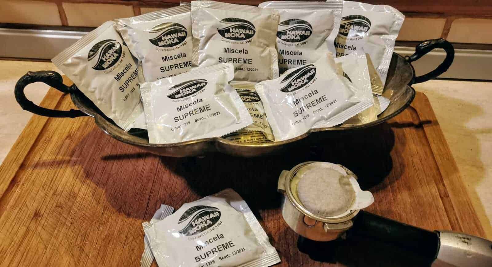 Sacchetti di zucchero di marca Hawaii Mokao in una ciotola di metallo su un bancone in legno, pronti per essere utilizzati in cucina per dolci o bevande calde.