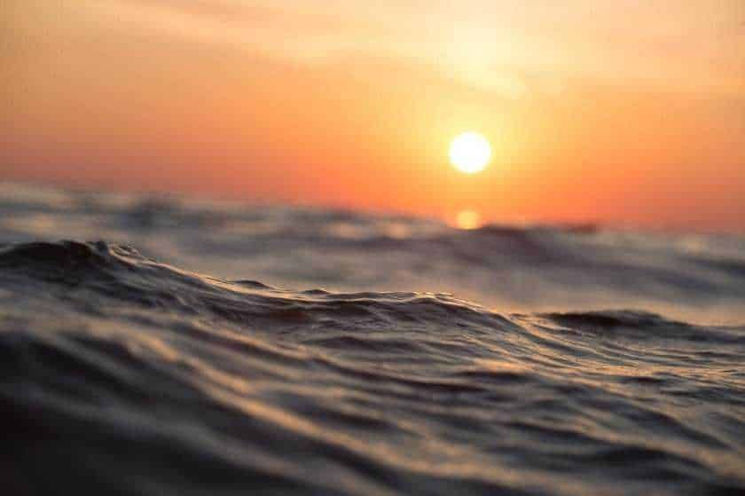 Tramonto sull'oceano con onde e cielo colorato al crepuscolo, atmosfera rilassante e naturale.