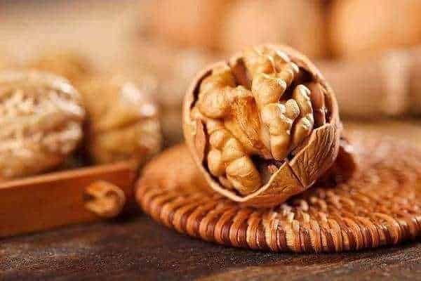 Benefici per la salute della donna: So}+n, il frutto secco di noci sulla tavola in un contesto rustico, ideale per articoli su alimentazione sana, benefici delle noci, e ricette naturali.