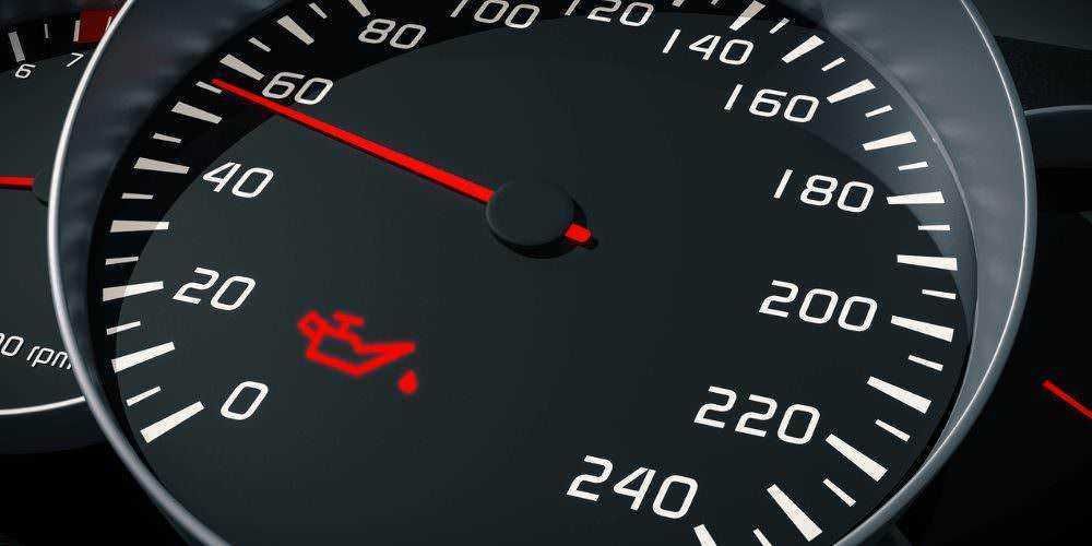 Motore in stato di allerta sulle lancette del cruscotto auto, simbolo di controllo olio motore, sfondo nero e dettagli chiari per immagini auto e manutenzione veicolare.