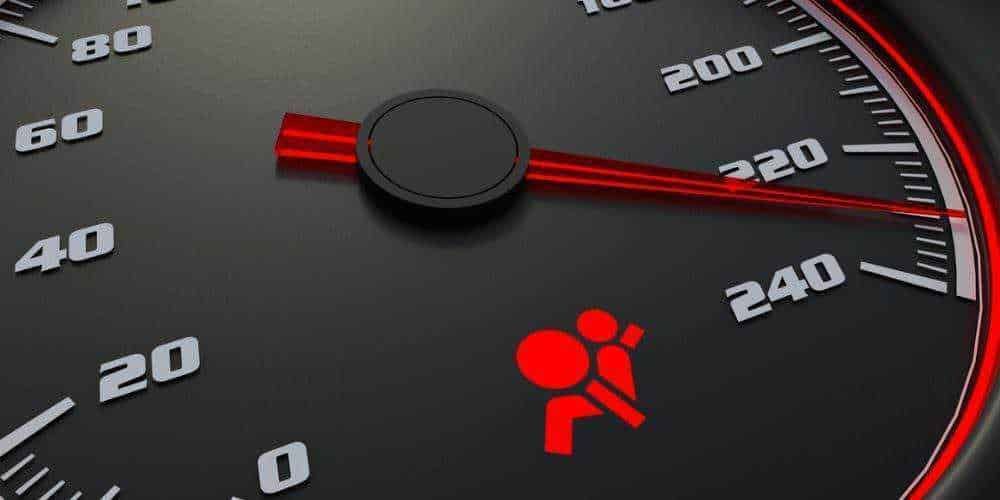 Velocità massima del tachimetro dell'auto con luci rosse di avviso sicurezza in evidenza.