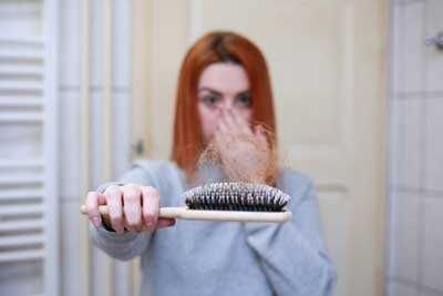 Spazzola per capelli e donna che si asciuga i capelli con aria calda, cura dei capelli, routine di bellezza, prodotti per la cura dei capelli, bellezza e stile.