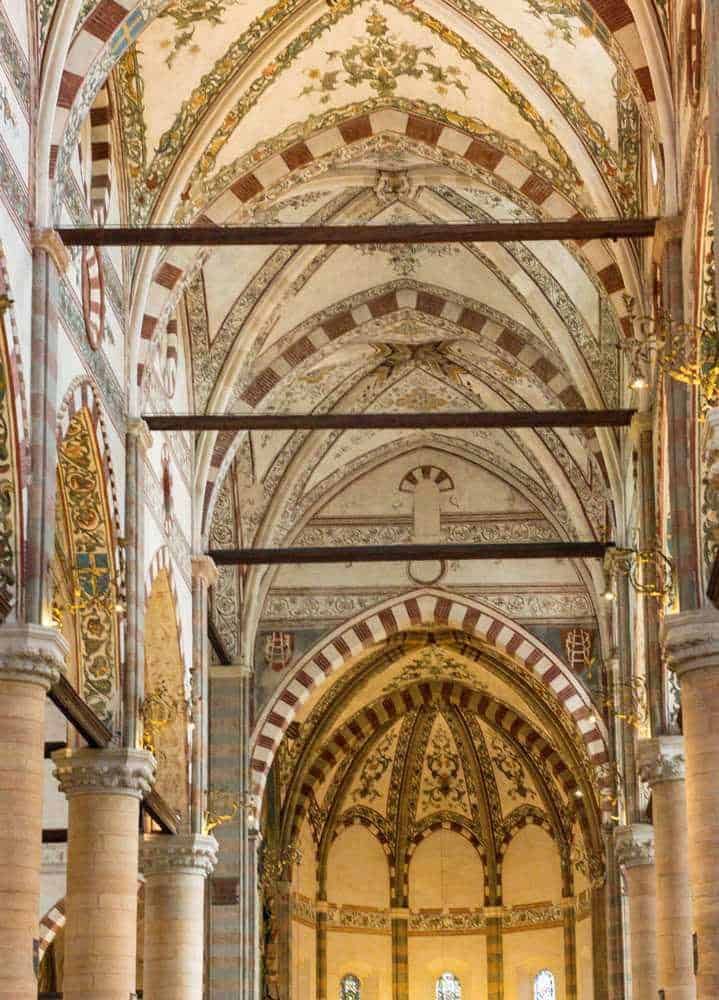 Dove si trova Verona, Meteo e cosa vedere nella Piccola Roma (2026) 13 Finestra artistica sul soffitto di una cattedrale, dettagli di architettura gotica, decorazioni barocche con affreschi, colonne imponenti e archi elaborati, interni storici e artistici.