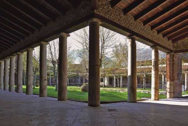Un portico storico con colonne di pietra che conserva un'architettura antica in un ambiente naturale e tranquillo.