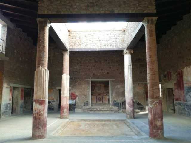 Restauro di un sito archeologico romano con colonne in mattoni e affreschi antichi, testimonianza della storia e dell'arte dell'antica Roma.