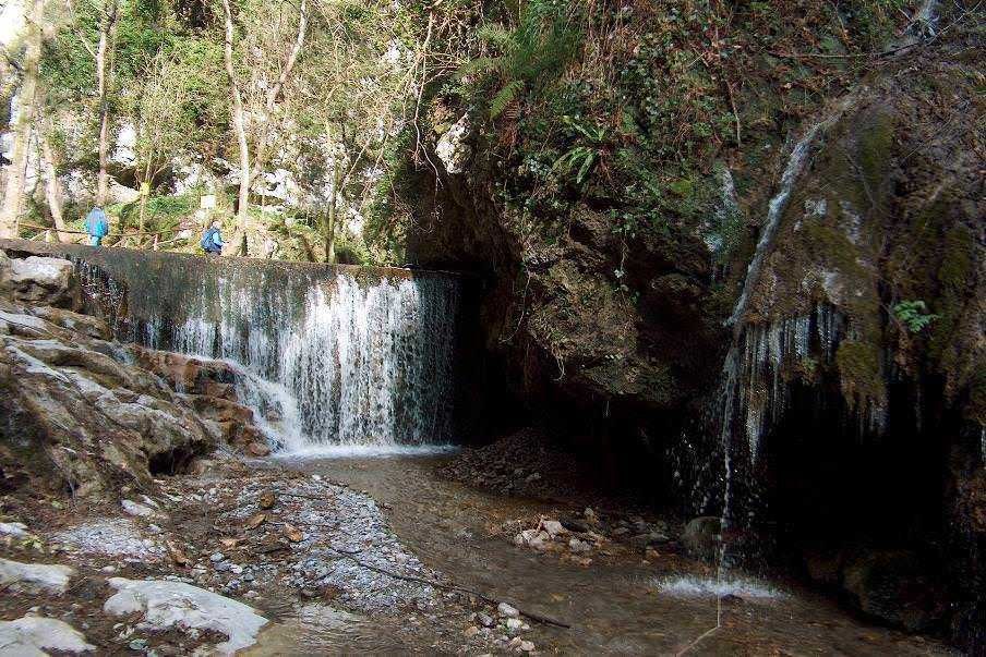Fiume con cascate naturali in un'area boschiva, escursione in natura, ambiente selvaggio con rocce e vegetazione rigogliosa, escursionisti che esplorano un coi rivi e cascate di montagna.