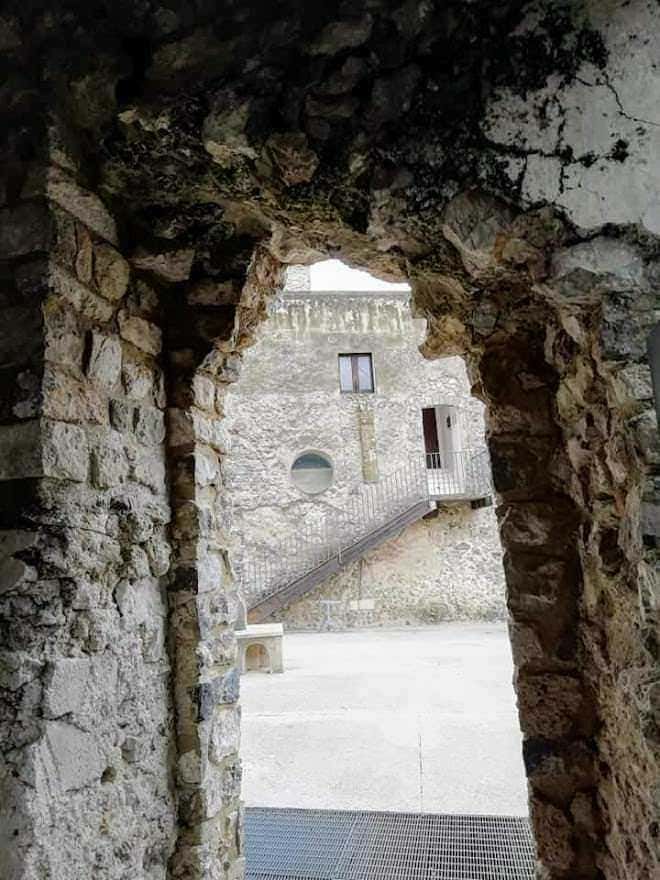 Architettura storica, castello in pietra, veduta attraverso arco, edificio medievale, ambiente antico e suggestivo, struttura in pietra, viaggio culturale, attrazione turistica, paesaggio urbano, patrimonio storico, Appunti Sul Blog.