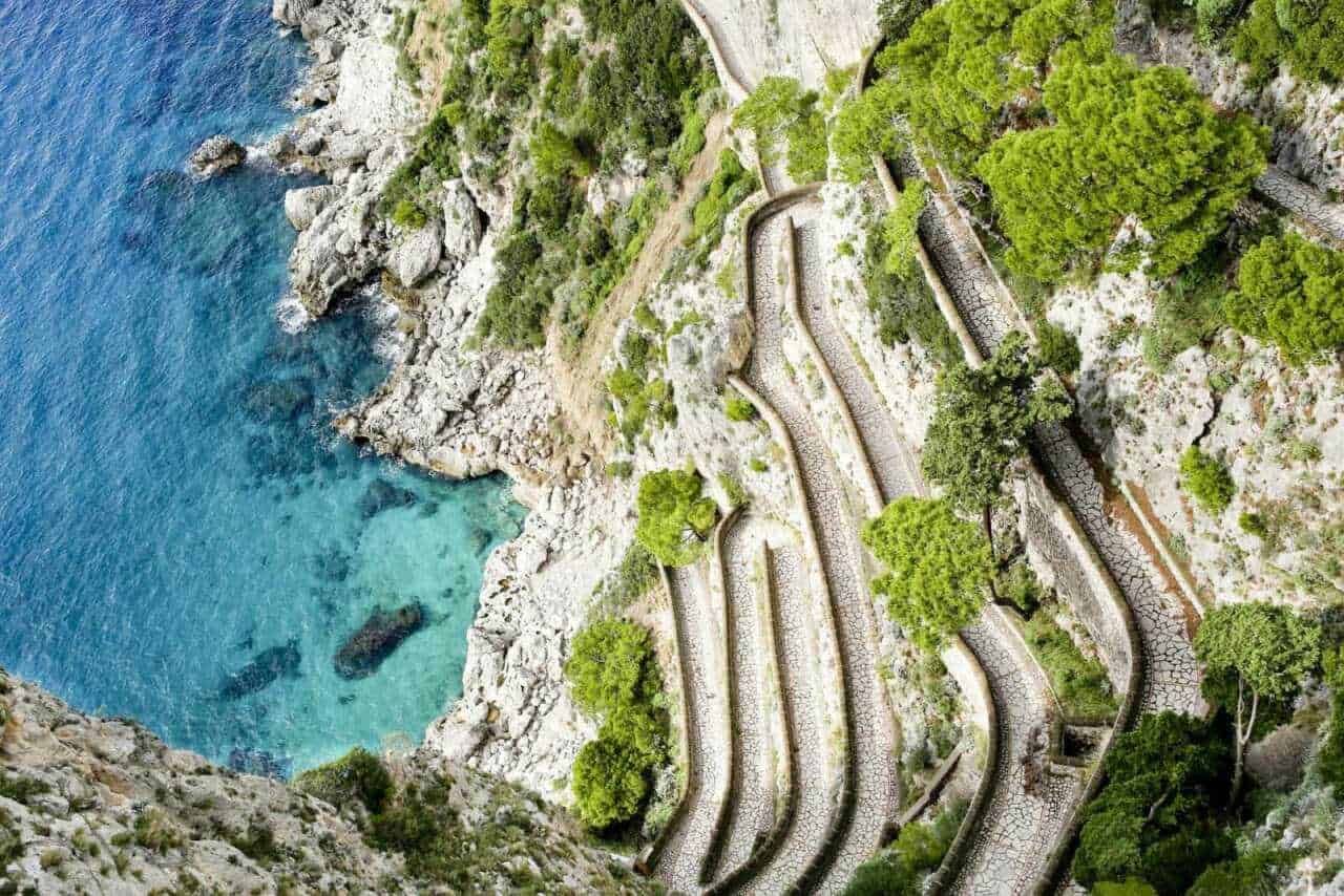 Via Krupp, sentiero a a zig zag lungo la scogliera con verdeggianti alberi e acque cristalline.