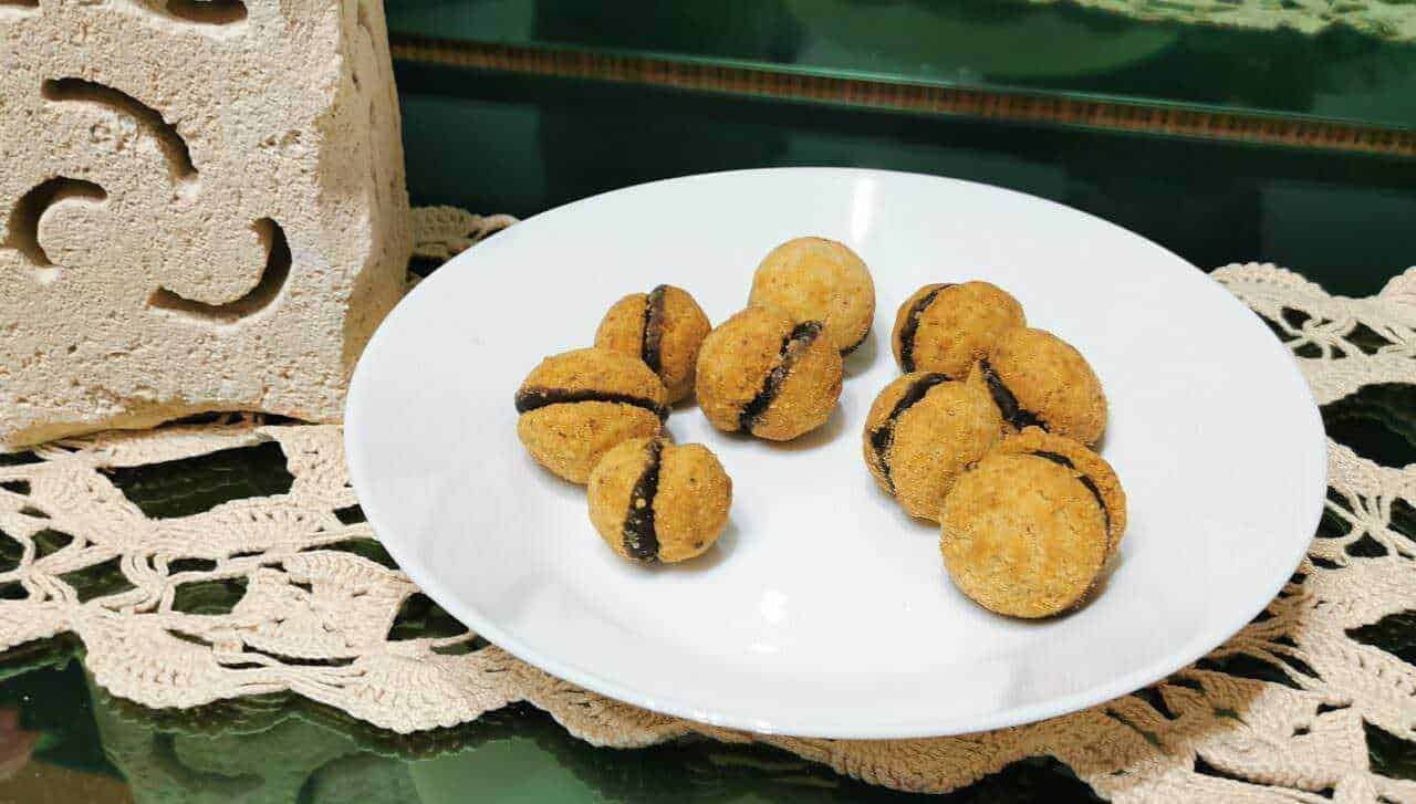 Crocchette di pasta ripiena con crema di cioccolato su piatto bianco, dolci fatti in casa, snack goloso e invitante, perfetto per merenda o dessert, fotografia di cucina italiana.