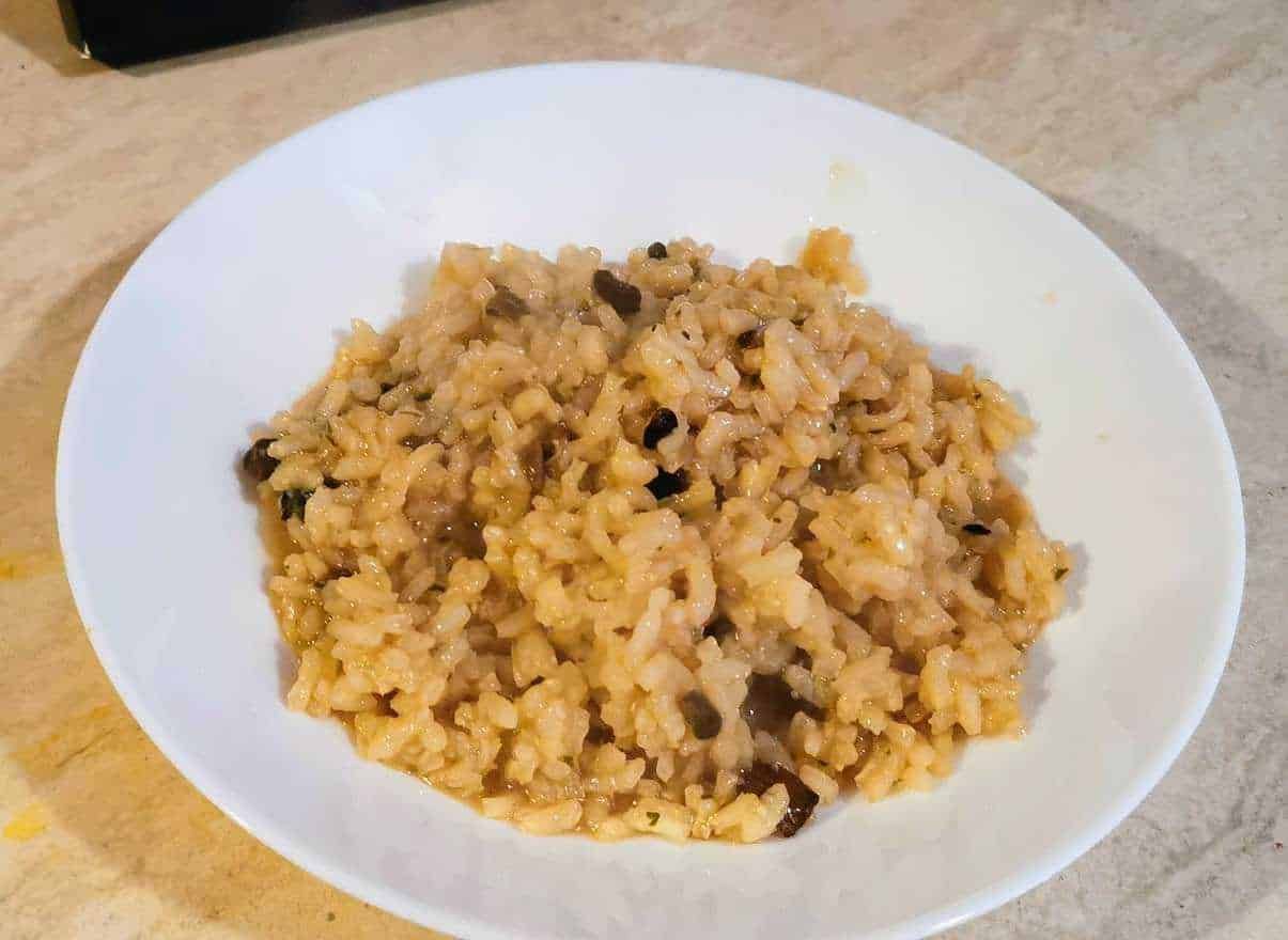 Risotto ai funghi porcini in una ciotola bianca, piatto cremoso e saporito, perfetto per gustare i funghi selvatici in modo autentico. Ricetta facile e deliziosa ideale per pranzi e cene.
