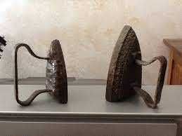 Antico ferro da stiro con piastra in ghisa e manici in ferro battuto, oggetto vintage per la casa.