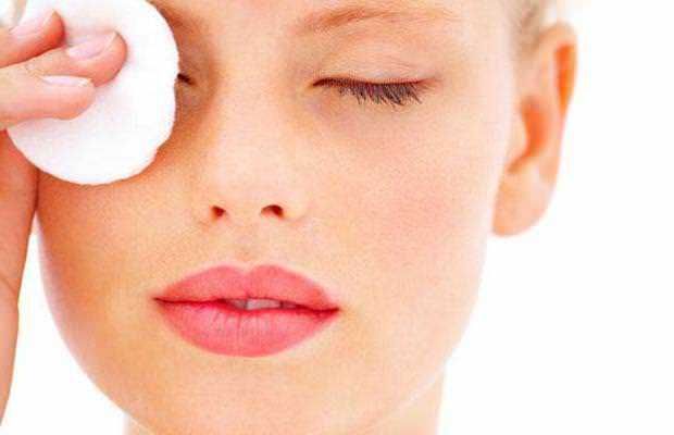 Magnifica immagine di una donna che si prende cura della pelle del viso con un batuffolo di cotone, ideale per contenuti di bellezza e skincare.