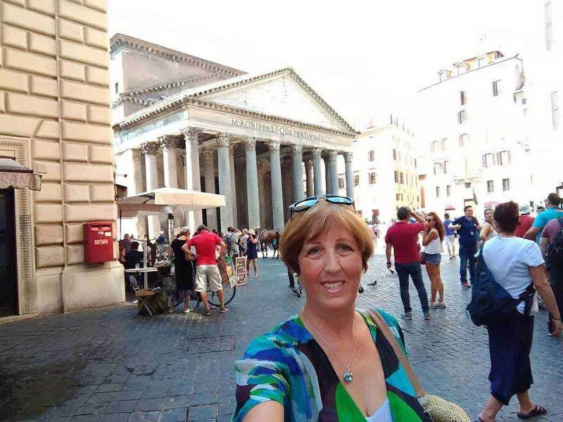 Storia del Pantheon disegno di un angelo 7 Antica piazza romana con il Pantheon sullo sfondo, turista sorridente che scatta selfie a Roma, edificio storico e atmosfera vivace turistica.