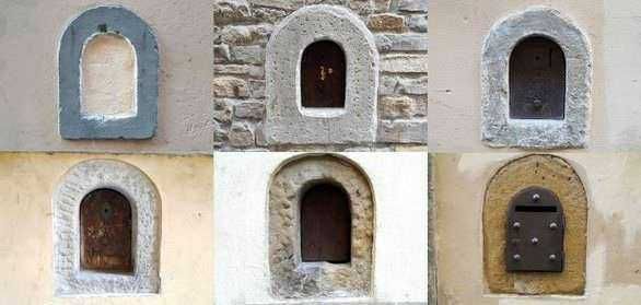 Antifurto postale con diversi modelli di contenitori per lettere sulla parete di un edificio.