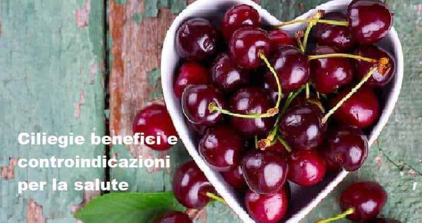 Ciliegie fresche in ciotola cuore con foglia verde su tavolo di legno rustico, meticolosa disposizione di frutta autunnale, immagini di alimenti salutari, naturali e nutrienti.
