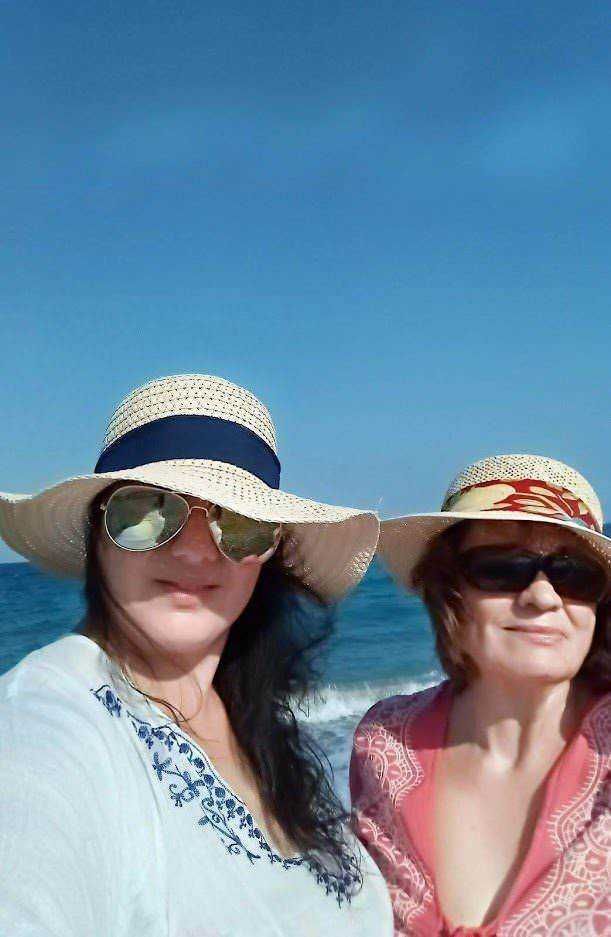 Donne con cappelli estivi al mare